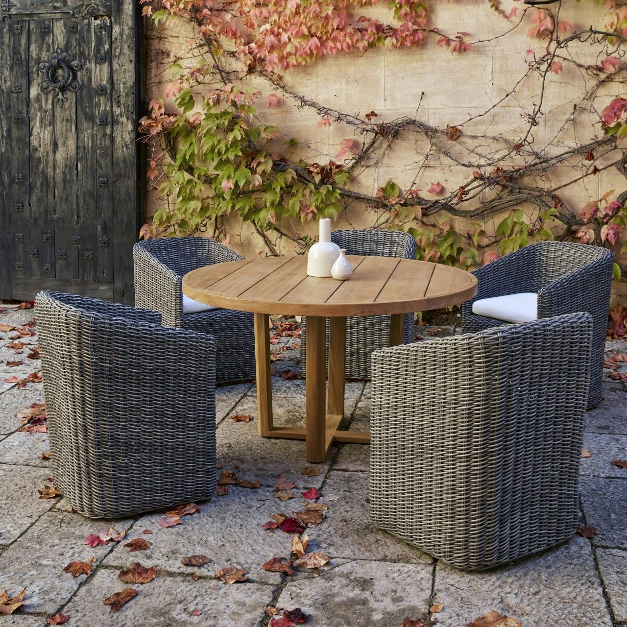 floor-length woven dining armchairs [ash grey wicker] and teak round dining table (Courtesy of POINT)