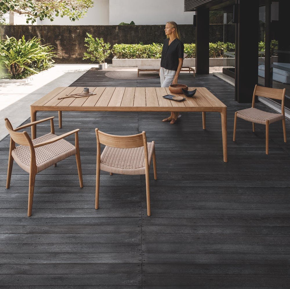 Slatted teak table top with dining armchairs and side chairs (Courtesy of Gloster)