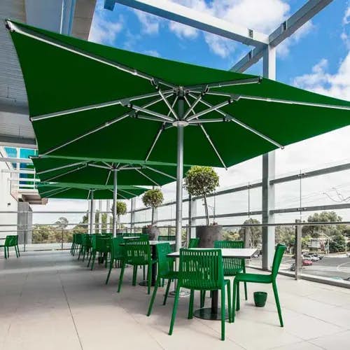 a sea of green: three nova 13' square giant patio umbrellas in forest green lined up