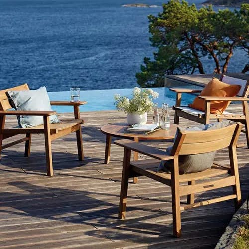 mix and match: two djuro all-teak lounge armchairs, one teak-fabric lounge armchair and djuro 31" circular lounge table