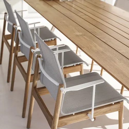 white sway dining armchairs with split teak dining table