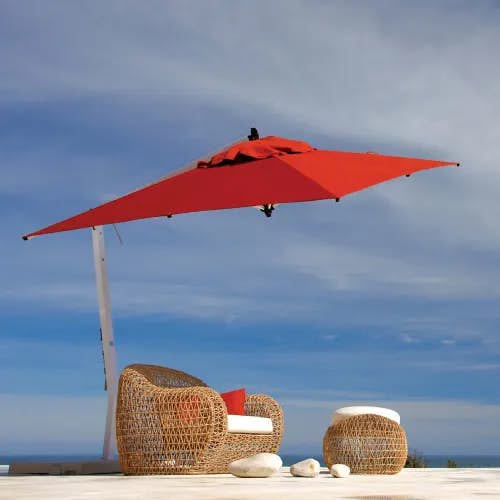 pop of color: 9.8" picollo square cantilever umbrella in red tilted to protect from the sun