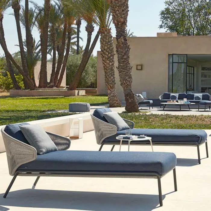 manutti outdoor setting (front to back): two radoc chaise lounges, two manutti poufs, and radius 3-seater, 2 1-seaters plus medium footstool