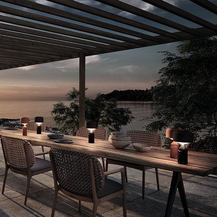 gloster ambient pebble lantern illuminates a dining table at dusk