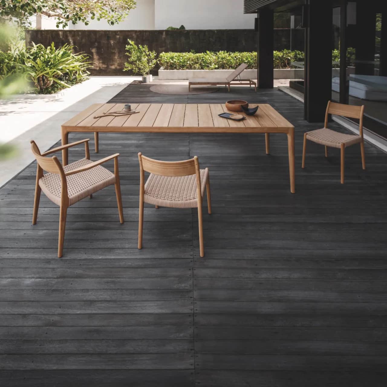 Slatted teak table top with dining armchairs and side chairs (Courtesy of Gloster)